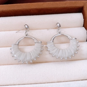 Detailed macro view of vintage silver earrings with white pleated leather and metal beads