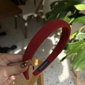 Gros plan d'un serre-tête tricoté rouge avec étiquette faite main et texture torsadée