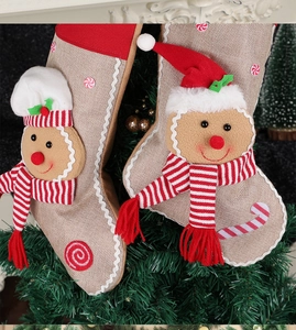 Detail of Christmas stocking hanging on a tree with a plush gingerbread man and candy embroidery