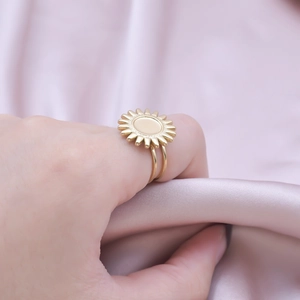 Close-up of golden sunflower ring with double band design on elegant purple silk