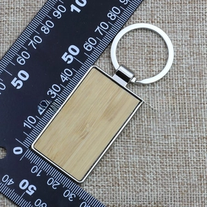 Macro view of rectangular bamboo and silver metal keychain on measuring tool