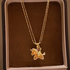 Vue détaillée du collier licorne plaqué or 18 carats avec cristaux dans un coffret en daim