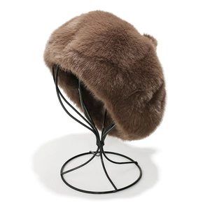 Detail view of brown faux mink fur beret with leopard texture on a black wire display stand