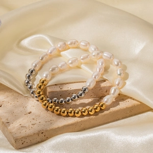 Détail du bracelet en perles d'eau douce et perles dorées sur socle en pierre