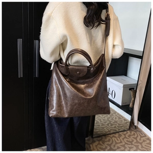 Bruine vintage leren tote bag op model die de grote capaciteit en grootte toont