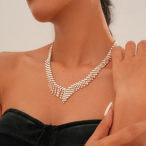 Close-up of sparkling V-shaped tassel necklace with diamonds on model neck