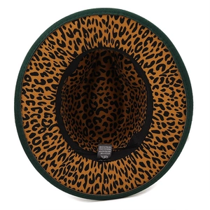 Détail d'un chapeau fedora avec extérieur en feutre vert et doublure léopard chic