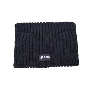 Close-up of black knitted headband with vertical ribbed texture and grey logo patch
