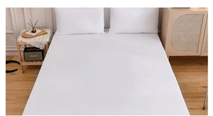Minimalist white bedding set with fitted sheet and pillowcases in a cozy bedroom setting