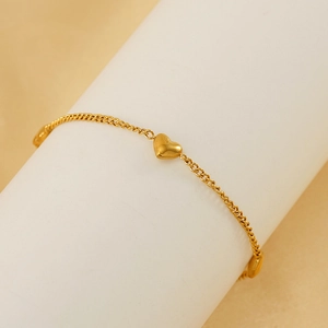 Vista macro detallada de una pulsera de eslabones de acero inoxidable dorado con corazón