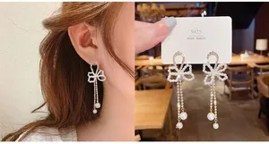 Close-up of S925 silver needle bow earrings with elegant long pearl tassels