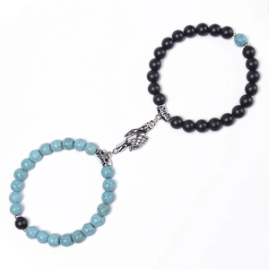 Detail of couple magnetic bracelets with blue turquoise, black matte beads and hand charms