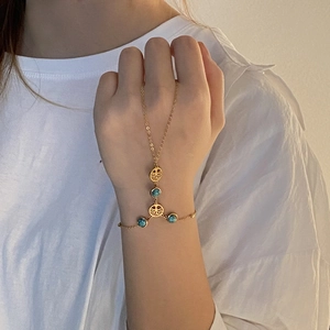 Detailed close-up of golden finger bracelet featuring tree of life and blue stone beads