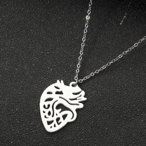 Detailed macro view of an anatomical heart pendant with hollow-out silver-tone metal finish