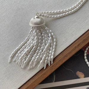 Detail of white pearl fringe necklace showing lustrous beads and silver metal textures