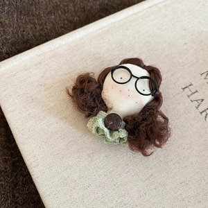 Detailed close-up of a cute flocked teddy bear brooch on a rustic beige linen book