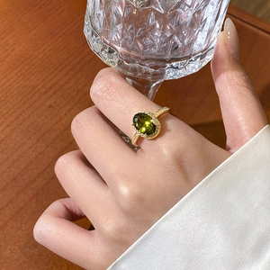 Elegant 18k gold plated ring with oval emerald zircon shown in a luxury lifestyle setting
