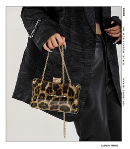 Detail of square leopard print evening bag with elegant gold chain strap and metal clasp
