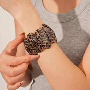 Gros plan d'un bracelet chic en résine à motif léopard au poignet au design large élégant