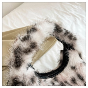 Detail of soft black and white spotted faux fur texture on this plush crescent handbag
