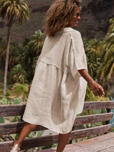 Detail view of off-white linen shirt dress showing breathable fabric and side profile