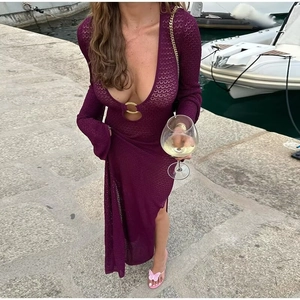 Detalle de vestido largo de punto con escote en V profundo, aro dorado y manga campana