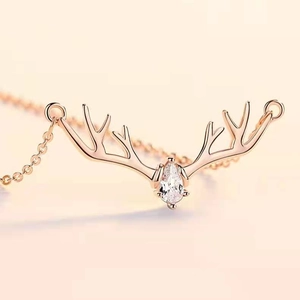 Macro shot of rose gold reindeer antler necklace with a teardrop zircon pendant detail