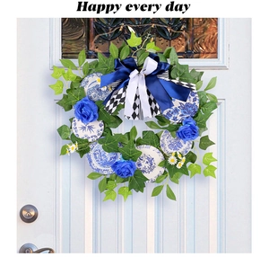 Detail of faux greenery wreath with blue roses, porcelain plates, and a large bow