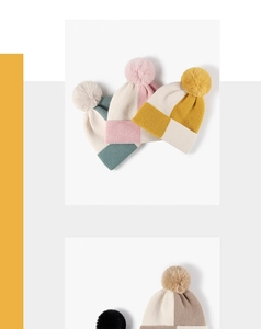 Close-up of knit winter hats with contrast color blocks and fluffy pom-pom details