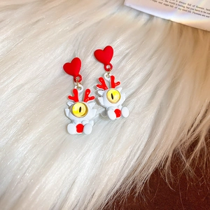 Vue détaillée des boucles d'oreilles cœur avec yeux de dragon sur fausse fourrure