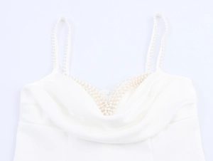 Detailed view of elegant cowl neck white dress with pearl beaded straps and silky fabric