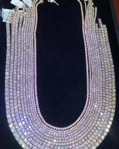 Macro shot of 14K white and rose gold tennis necklaces with moissanite diamonds in a box