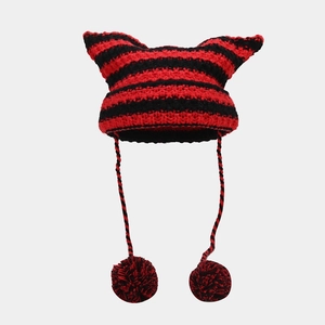 Détail du bonnet en tricot rayé rouge et noir avec oreilles de chat et pompons