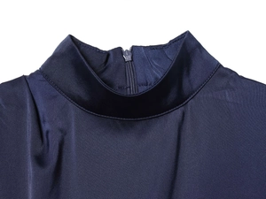 Dettaglio dello scollo dell'abito in raso blu navy con collo alto e cerniera invisibile