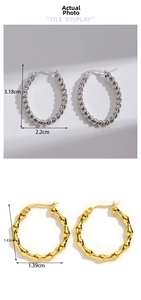 Close-up of silver twist rope hoop earrings and gold bamboo style metal ear rings
