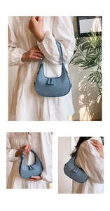 Detailed view of the blue woven texture and elegant crescent shape on this underarm bag