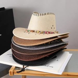 Close-up of stacked western straw cowboy hats in multiple colors with beaded bands