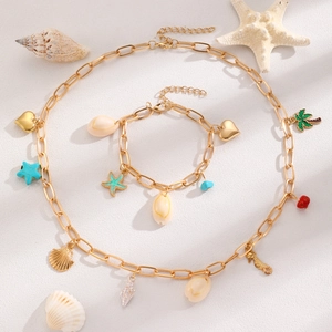 Detailed view of gold ocean-themed necklace and bracelet set with starfish and shell charms