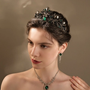 Detail of baroque black-gold tiara and jewelry set with deep emerald green gemstones