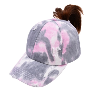 Close-up of distressed tie-dye ponytail baseball cap with pink and grey marbled patterns