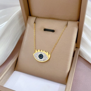 Gold titanium steel Evil Eye necklace with blue gemstone in a luxury jewelry box