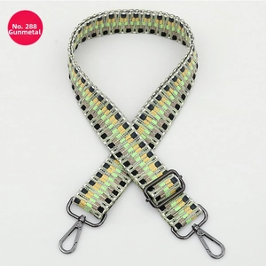 Detail of adjustable woven purse strap with geometric pattern in green and yellow
