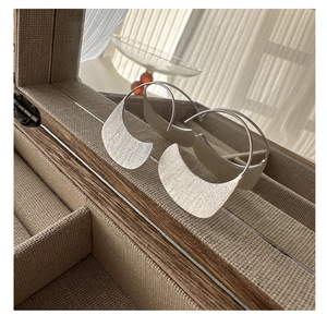 Macro detail of S925 sterling silver crescent earrings with a brushed matte finish texture