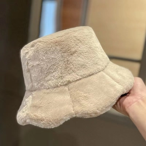 Macro shot of soft faux rabbit fur texture on a beige winter bucket hat for women