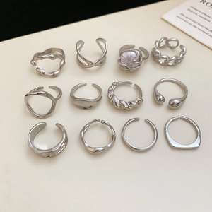 Flat lay of a 12-piece silver irregular geometric ring set with pearl detail