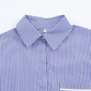Détail du col d'une chemise à rayures bleues et blanches avec étiquette taille S