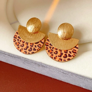 Detailed view of fashionable leopard print round earrings with golden textured metal