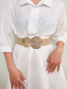 Detail of beige elastic woven belt featuring ornate double circular gold metal buckles