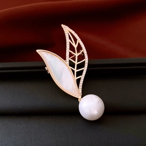 Macro view of 14K gold leaf brooch with pearl and mother-of-pearl inlay detail