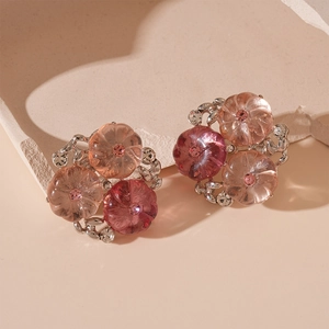 Macro shot of resin flower earrings with pink gradients and sparkling crystal accents